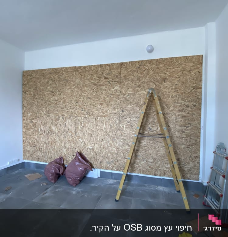 סולם עץ, לוחות עץ, שקי פסולת, כלים על הרצפה